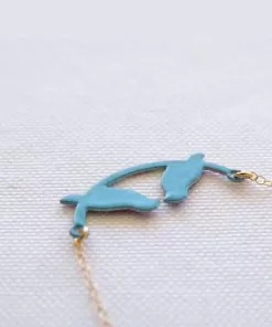 A lovebird necklace on a little turquoise swing