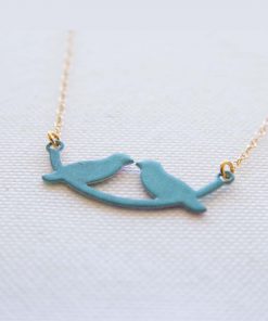 A lovebird necklace on a little turquoise swing